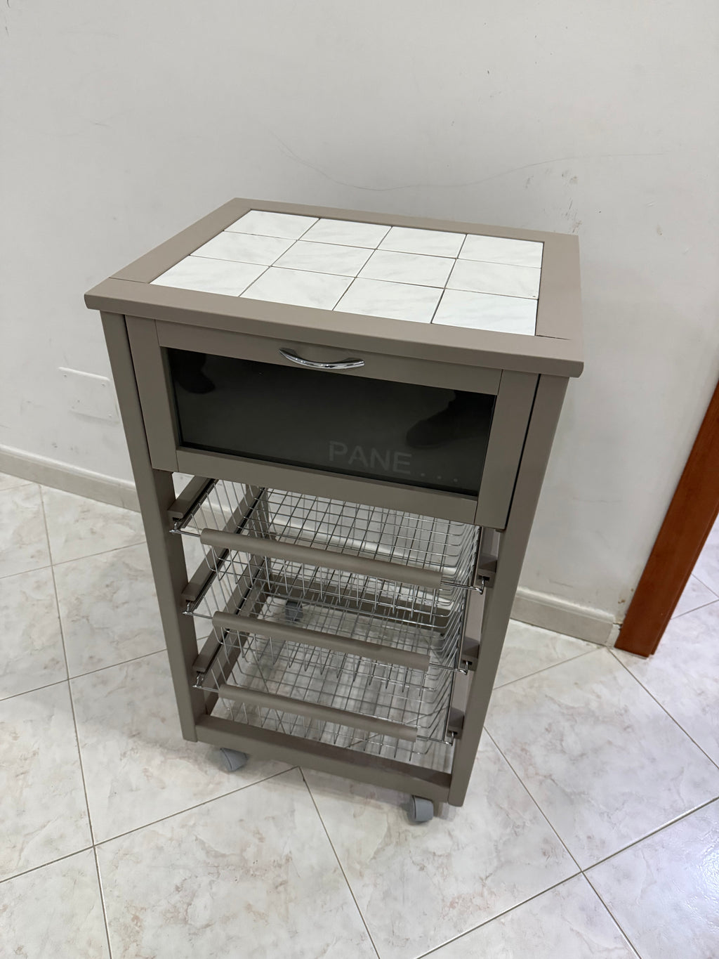 CARRELLO CUCINA IN LEGNO PER PORTAVERDURA CON 3 CESTINI, CASSETTO PORTAPANE E RIPIANO IN MATTONELLE.
TORTORA